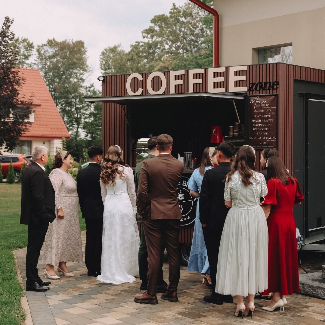 Wedding guests queueing at a mobile coffee truck labeled COFFEE zone in an outdoor setting.